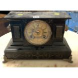 Black slate mantle clock with ormolu mounts with brass face and pendulum. 16” long x 10” high.