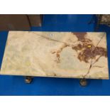 Onyx top coffee table with gilt cherub base. 39” long x 19.5” wide x 17” high.