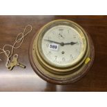 Round brass ship’s clock on wooden base, 11”diameter, with key