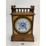 Walnut gallery top 2-hole mantle clock with blue/white enamel face and brass inlay. With pendulum
