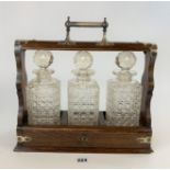 Tantalus with plated handle and hinges and 3 glass bottles, 15” long x 14” high