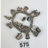 Silver charm bracelet with heart lock and 17 charms, total w: 2 ozt