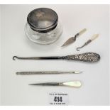 Silver lidded glass jar, silver handled button hook, 3 mother of pearl handled tools and metal tool