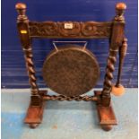 Twistleg carved wood and brass dinner gong with striker, 20”l x 11”d x 25”h