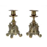 Pair of 19th Century brass candlesticks, with circular sconces over serrated drip pans, raised on