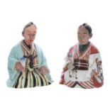 Two Chinese glazed stoneware figures modelled as seated gentlemen, one with a fan, the other with