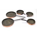 Group of five Victorian copper frying pans, two 14.5" diameter, one 11" diameter and two 10"