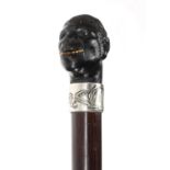 Silver mounted walking cane, the handle/pommel carved as a gentleman, the silver collar marked '800'