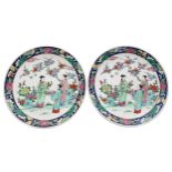 Pair of Chinese porcelain plates, decorated with figures in a garden with a blossom tree, within a