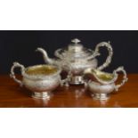 Fine William IV three piece silver tea set, densely repousse decorated with flowers within C