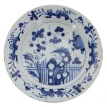 Antique blue and white tin glaze porcelain dish, decorated with plants and blossom within a floral