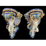 Good large pair of majolica glazed pottery wall brackets, modelled as putti figural supports with