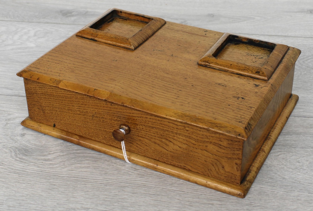 Early 20th century oak desk stand, with recesses for square glass ink bottles (missing) over a