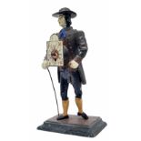 Novelty painted spelter street clock vendor, dressed in a dark green waistcoat and black breeches,