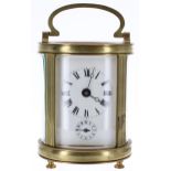 French carriage clock timepiece with alarm sounding on a bell beneath the base, within an oval brass