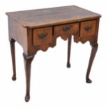 Georgian walnut low boy, the quarter veneered top over three short drawers and shaped frieze