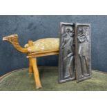 Carved camel stool with cushion, 18" high; together with a pair of varved hardwood African figural