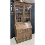 Oak bureau bookcase, the stained glazed upper doors enclosing a shelved interior over a fall front