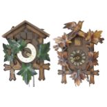 Two similar carved treen Black Forest type cuckoo clocks, one by Forestall, both with pendulum and