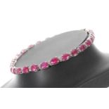 Modern 18ct white gold ruby and diamond line bracelet, set with twenty-six oval rubies, width 4mm,