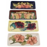 Four Moorcroft Pottery rectangular dishes, each with impressed factory stamps to the bases, one a