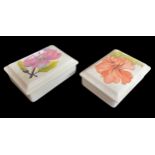 Two Moorcroft Pottery 'Hibiscus' rectangular trinket boxes with covers, decorated on a pale