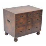 Oak campaign style chest of drawers of small proportions, with brass bound corners and recessed