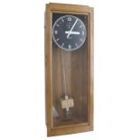 Inducta electric master clock, the 8.5" black dial with subsidiary seconds dial within a light oak