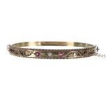 Victorian 15ct ruby and diamond three stone bangle, width 6mm, with safety chain, 8.4gm