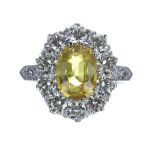 Good platinum yellow sapphire and diamond oval cluster ring, the sapphire 2.50ct approx, in a
