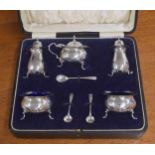 George V cased silver cruet set; comprising mustard with hinged cover enclosing blue glass liner,
