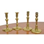 Two pairs of 18th century brass candlesticks, one pair over canted stepped bases, the