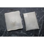 Two silver engine turned cigarette cases, the first of serpentine form with gilt interior,