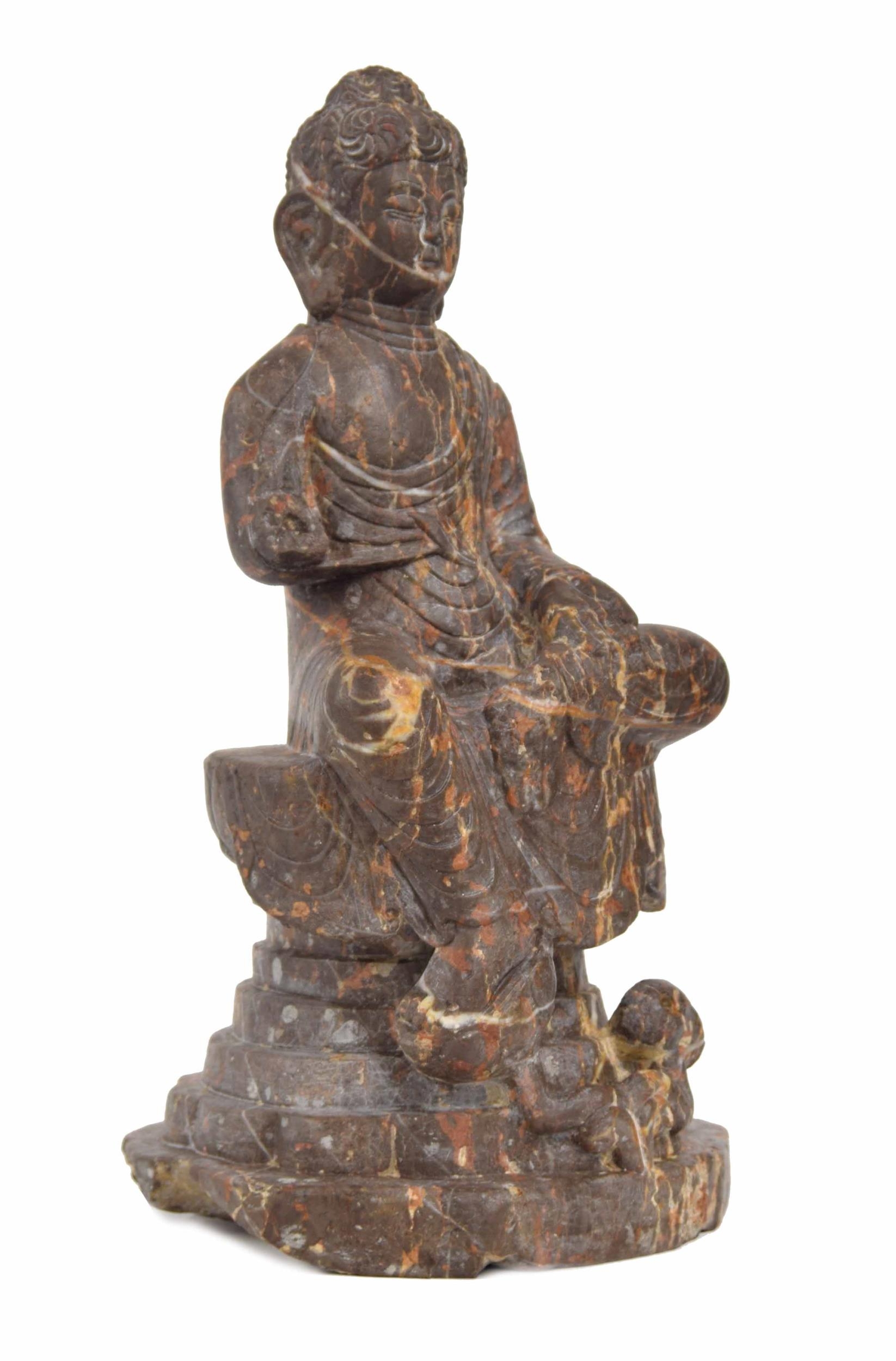Chinese veined rouge carved marble seated Buddha figure, modelled upon a stepped circular plinth,