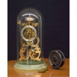 Brass skeleton clock striking on a bell, made in England, mounted upon a circular green onyx base