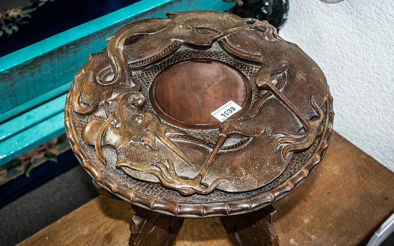 An Indian Carved Wooden Table, the top with raised stylised dragons, on four carved legs. Height - Image 2 of 2