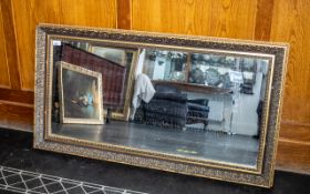 A Rectangular Mirror with Gilt Swept Moulded Frame. Overall size 25" x 45".