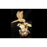Tagua Nut Amazonian Hand Made Figure, depicting a hummingbird and a flower.