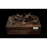 An Oriental Carved Cigar Box, the hinged lid surmounted by mythical beasts,