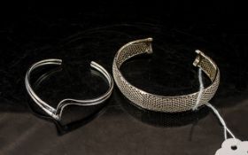Two Silver Bangles, comprising a solid twin band style bangle, and a silver mesh bangle.
