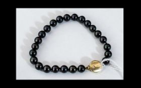 Black Pearl Bracelet set with a 14 carat gold decorative clasp. Measures 7".