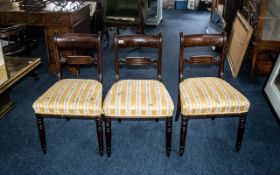 Three Mahogany Dining Chairs with carved back rests, upholstered seats, raised on column legs.