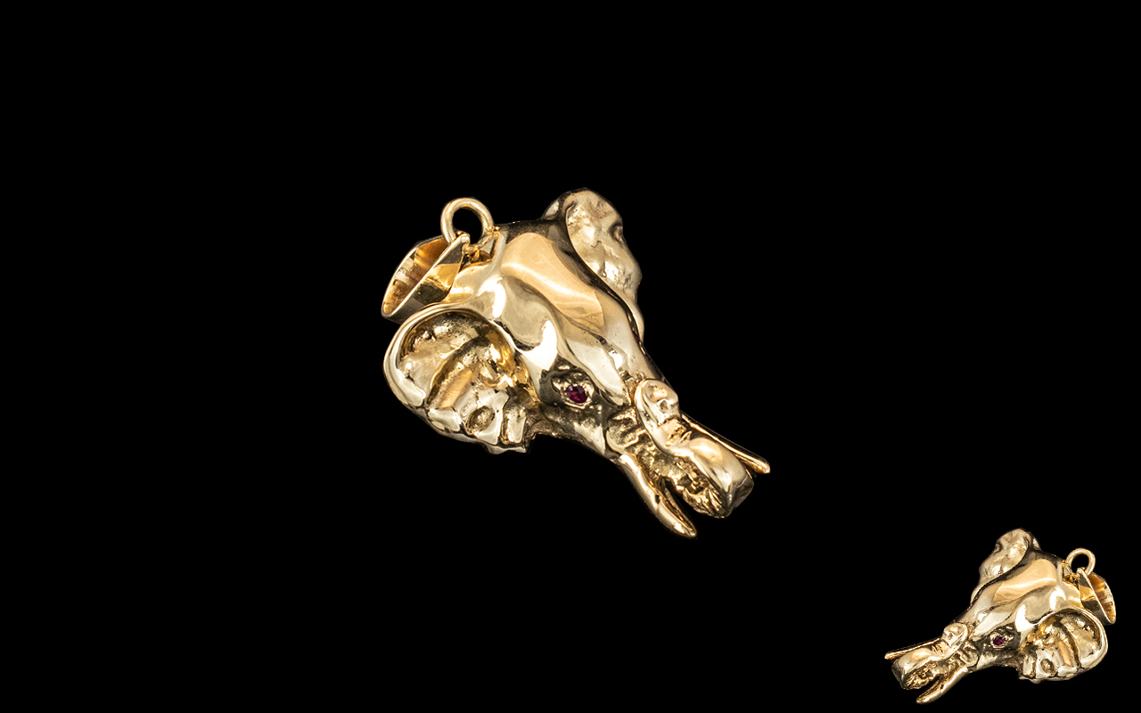 14ct Gold Elephant Pendant, trunk turned up, with ruby eyes. Fully hallmarked. Weight 4.5 grams.