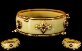 An Indian High Carat Gold Mounted Bangle, gold rims and enamelled and Ruby set spacers,