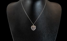 Silver Heart Shaped Locket on a White Me