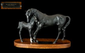 Beswick 'Black Beauty & Foal' raised on a wooden base. Measures approx 8" tall x 12" wide.