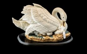 Spanish Porcelain Swan Group, depicting a swan with her cygnet, mounted on a wooden base. Marked