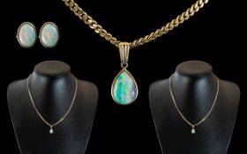 A 9ct Gold 18 inch Flat Curb Necklace suspended on an pear shaped opal pendant.