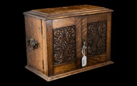 Oak Smoker's Cabinet, with two front opening carved wooden doors,