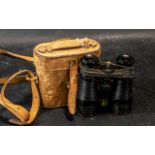 Pair of Binoculars housed in a tan leather case with carrying strap.